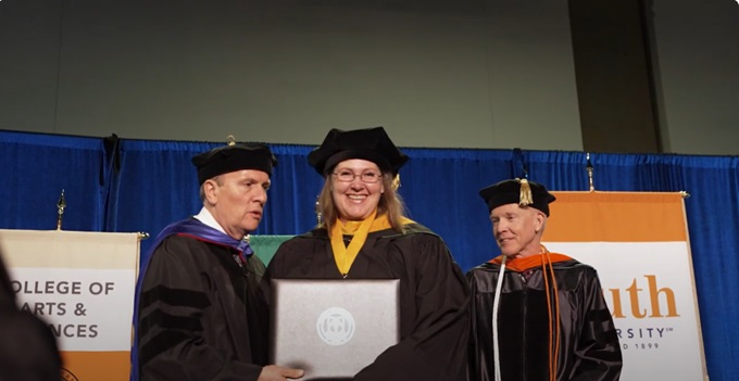 Vida Simonaitis receiving her diploma at the South University Criminal Justice graduation 2022
