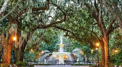 park with street lights on and water flowing from the foundatin