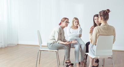 group of 4 women sitting down in a circe having a conversation