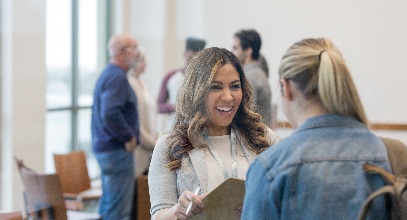 two women speaking with each other in a classroom setting