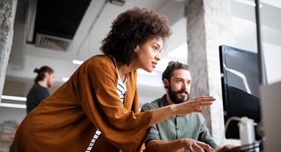 woman and a man working together on a project at a computer