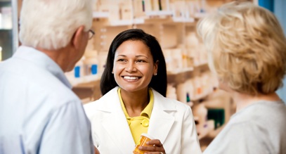 female pharmacist speaking with two older people at the pharmacy counter