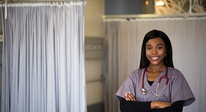 young african american woman in purple scrubs standing in a hospital room