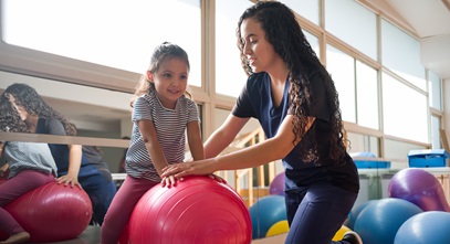 young girl working with a female occupational therapist in a gym setting