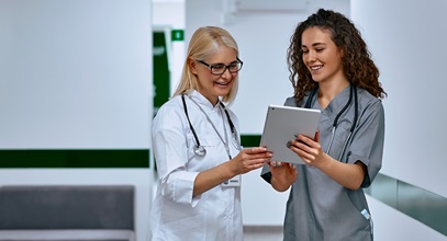 two women healthcare workers discussing findings on a tablet