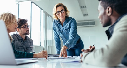 group of male and female professionals discussing a project in a conference room