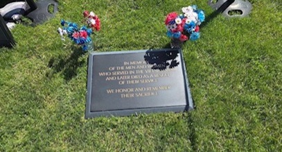 vietnam memorial grave stone with a bouquet of flowers on either side