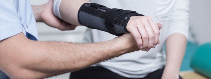 Occupational therapist holding patient's arm in cast