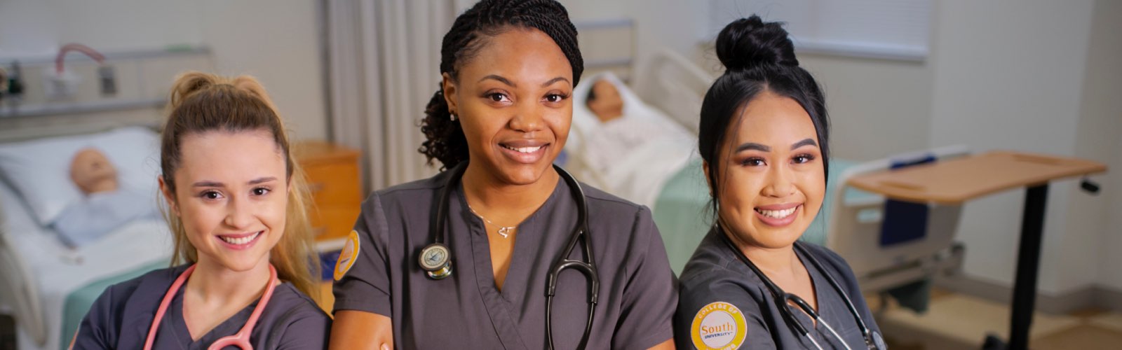 Group of female South University nursing students smiling in hospital room