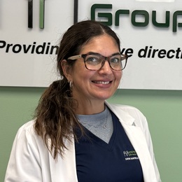Daymi Martin headshot in blue scrubs and a white coat
