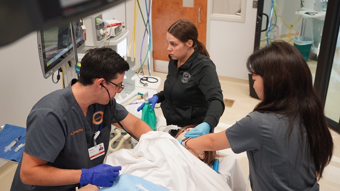 three anesthesia science students practicing in a simulation lab